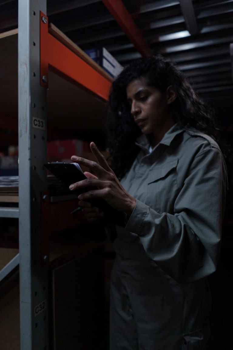 A dedicated female warehouse worker reviews inventory on a tablet.